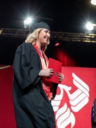 University of Phoenix alum Monica M. holds diploma at graduation ceremony